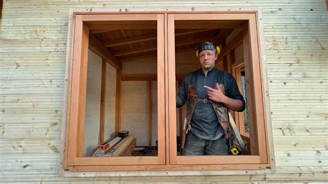 Artisan posant une fenêtre en bois