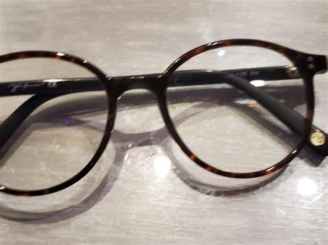 Gros plan sur les branches en équerre d'une paire de lunettes John Lennon