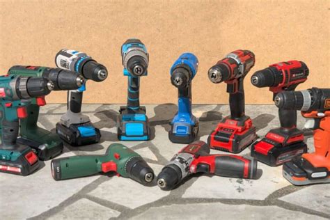 Un assortiment d'outils électriques sans fil, y compris des ponceuses, des perceuses et des visseuses, disposés de manière organisée sur un établi.