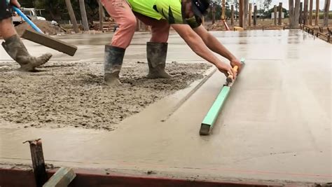 Technicien appliquant une chape sur un chantier